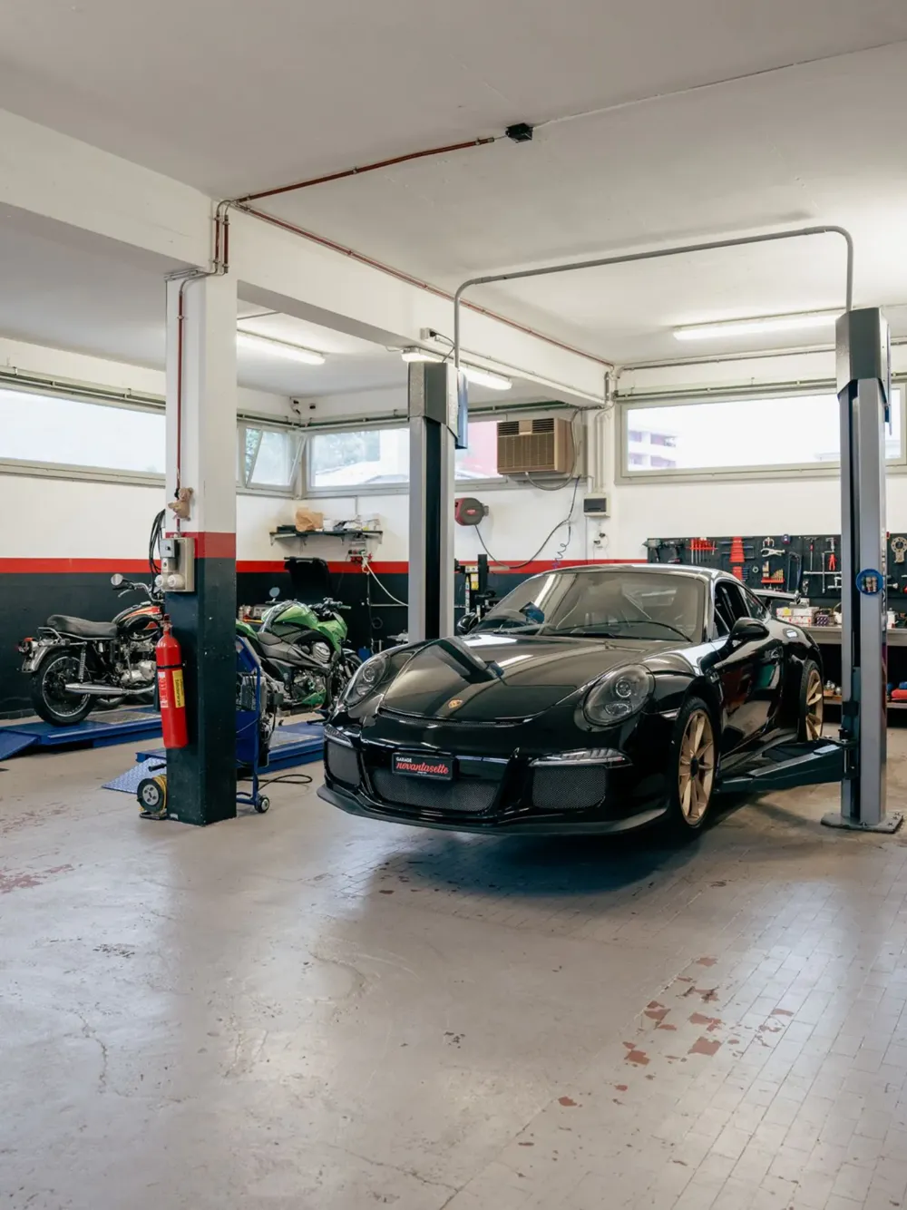 L'officina di Garage Novantasette con una Porsche nera sui ponti